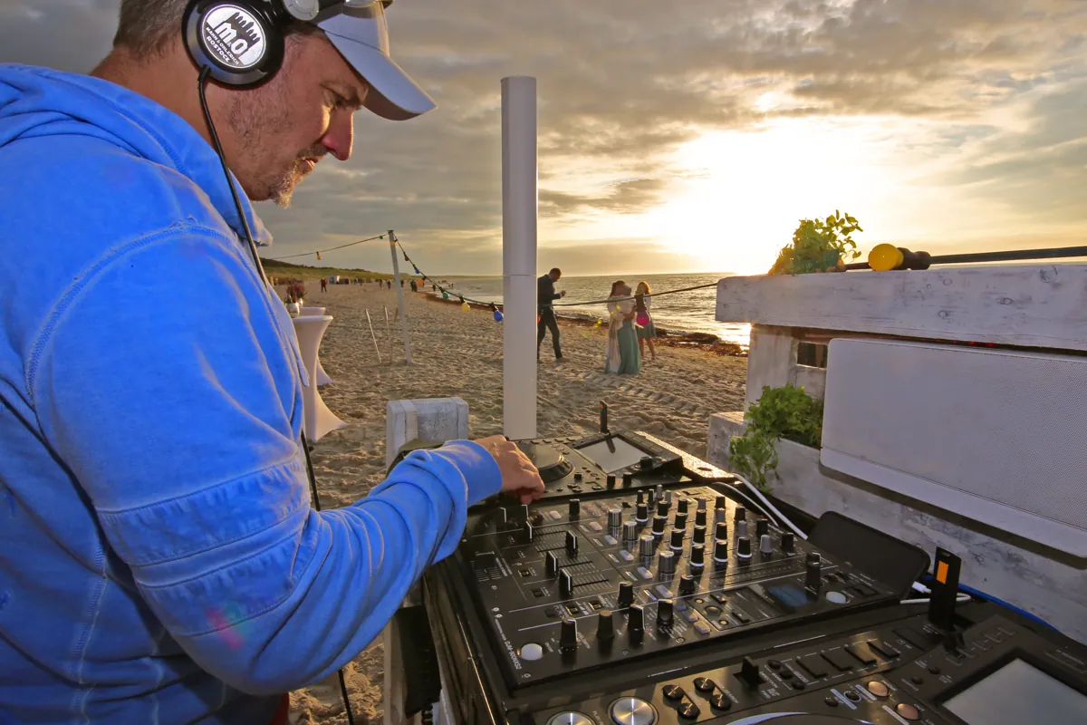 DJ am Strand bei Sonnenuntergang