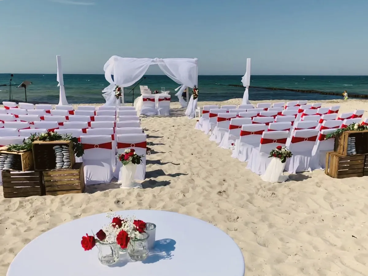 Aufbau für eine freie Trauung mit roter Deko am Strand von Markgrafenheide