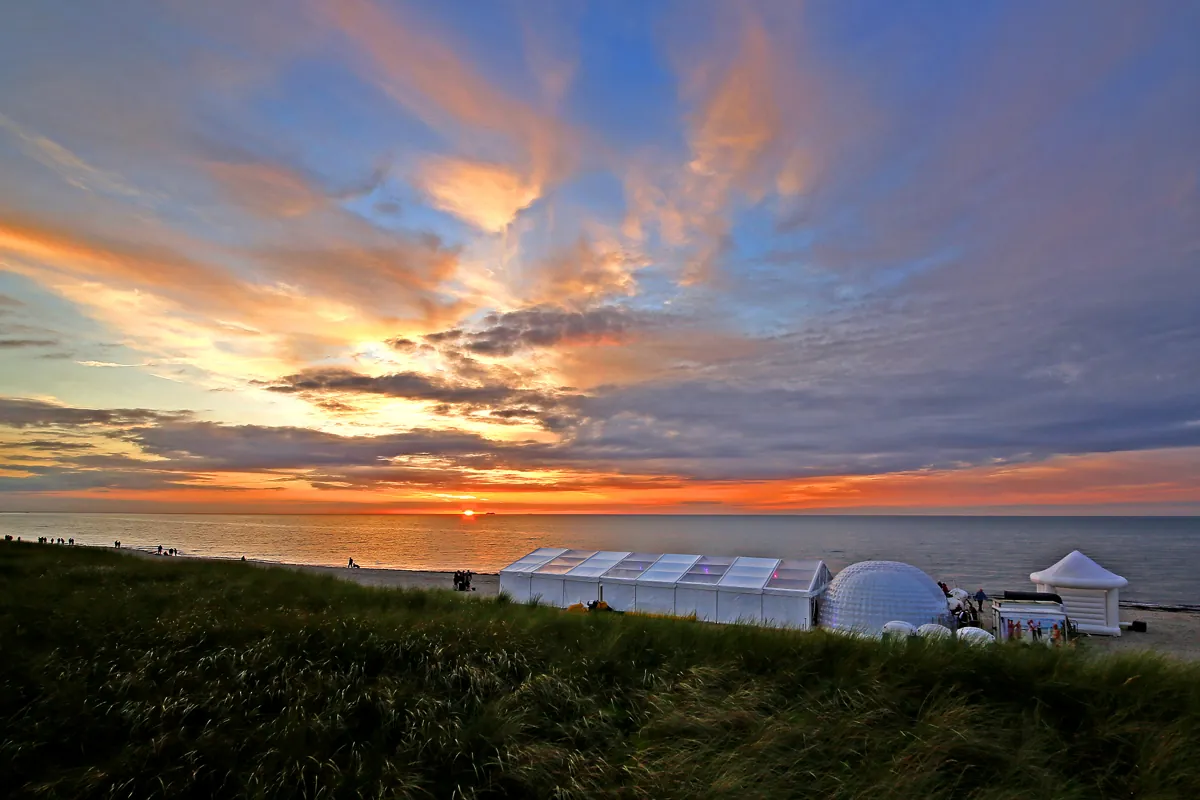 Sonnenuntergang über den Dünen, im Hintergrund das Hochzeitszelt